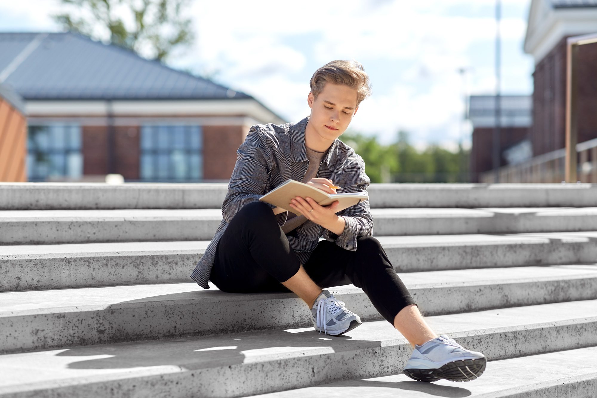 Teen boy writing in a gratitude journal